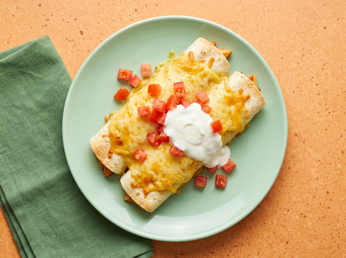 Overhead photo of cheesy chicken enchiladas with zingy tomato and yoghurt